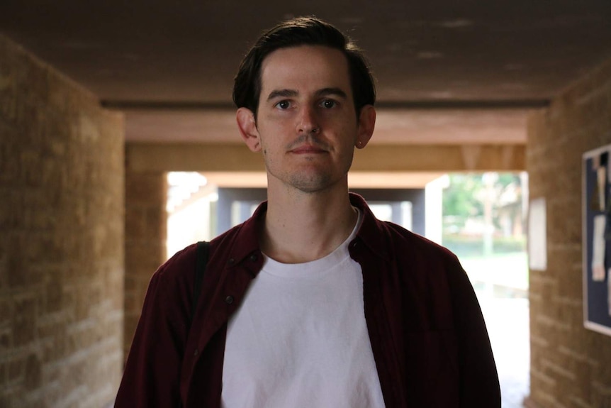 A close-up of a student standing in the corridor of a university.