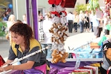 A woman with soft toys in a sideshow stall