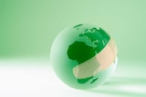 Green earth globe with a bandage on it.