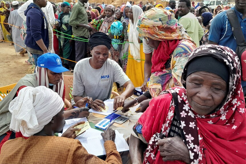 Sudanese refugees who have fled the violence in their country queue to receive food supplements from World Food Program.