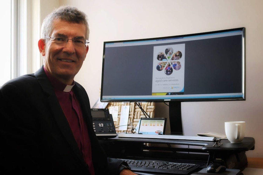 Anglicare chief executive officer Chris Jones sits at his desk