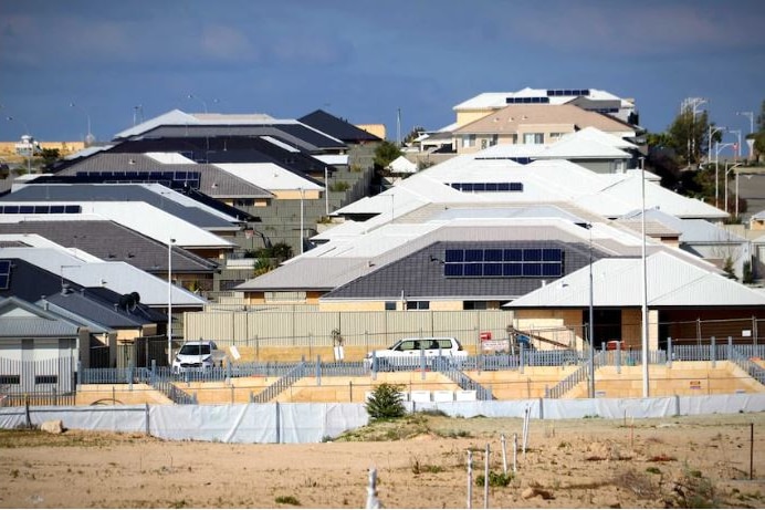 Rows of houses in background, with sand for a housing development in the foreground