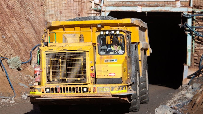 A yellow mining truck at the opening of a mine in the Goldfields