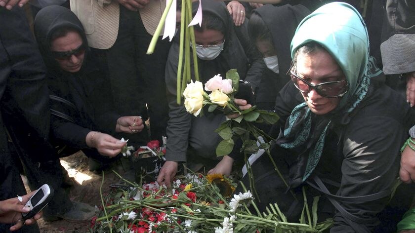 Iranians put flowers onto the grave of Neda Agha-Soltan