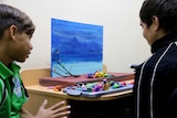 Two school students look at their plasticine models.