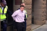 Harley Hicks being taken out of court by police