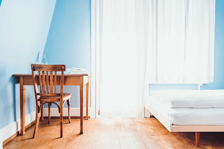 A bedroom with a window letting in light.