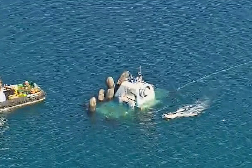 Aerial shot of a large generator sinking in water.