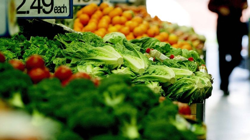 Vegetables sit in crates at a supermarket.