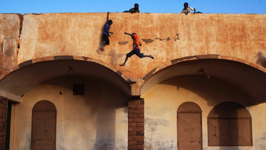 Boys play on the roof of the entrance to a football stadium in Gao, Mali.