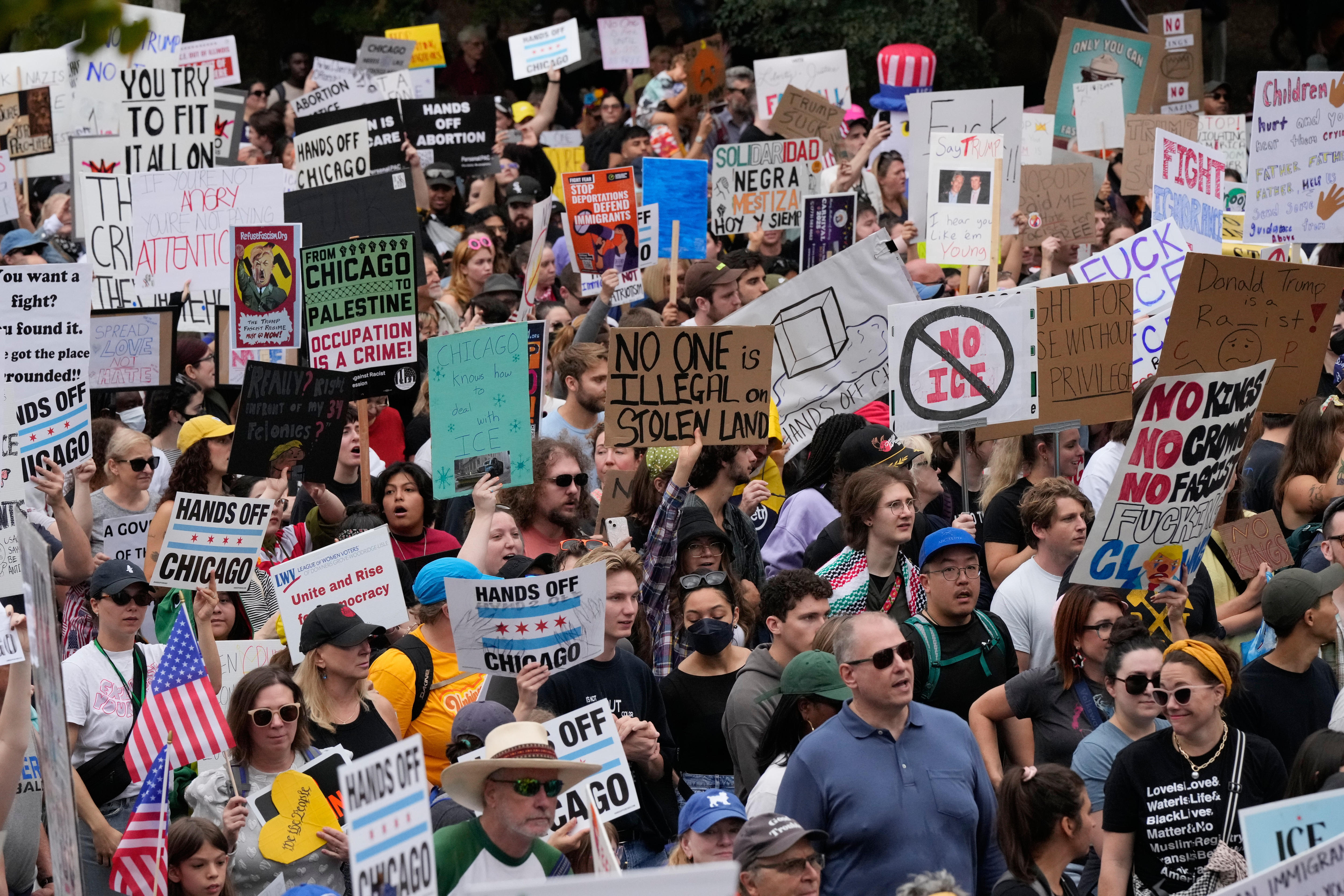 A mass crowd of protesters with many placards and signs showing political slogans and messages