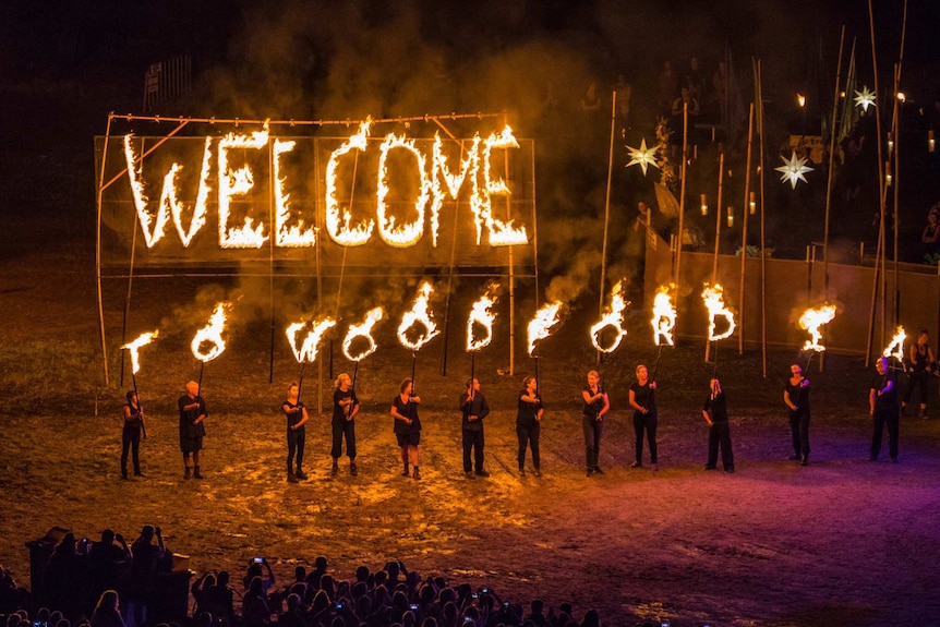 A firey sign reading welcome to Woodfordia