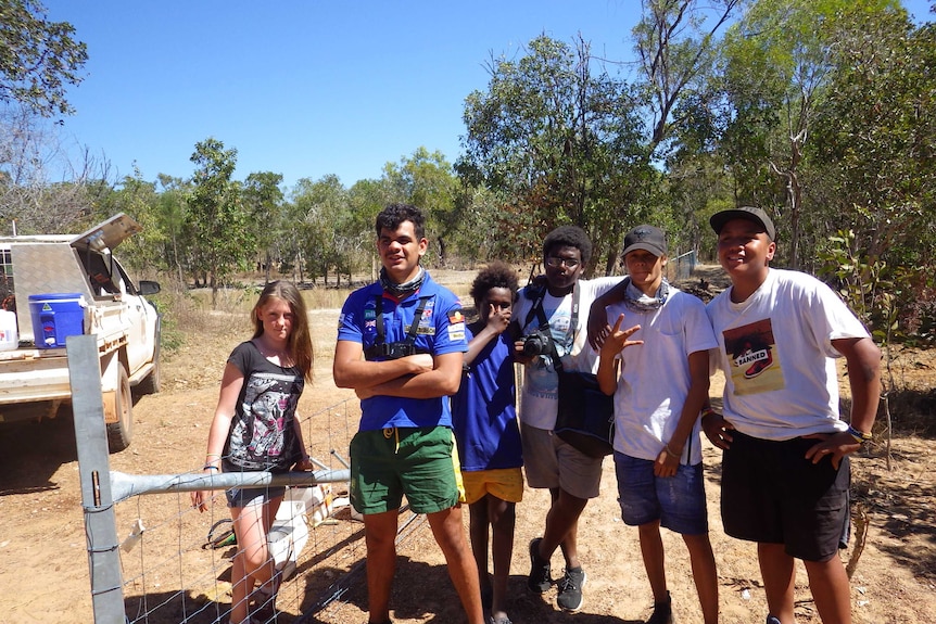 A Cairns student unrolling some fencing wire in Cooktown.