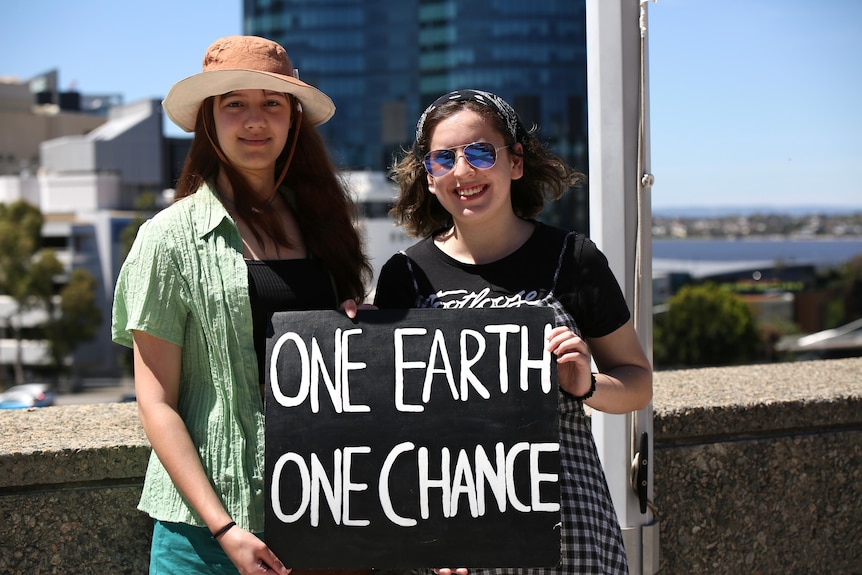 Two women holding a sign saying ONE EARTH ONE CHANCE
