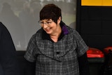 A woman in a winter coat and glasses.