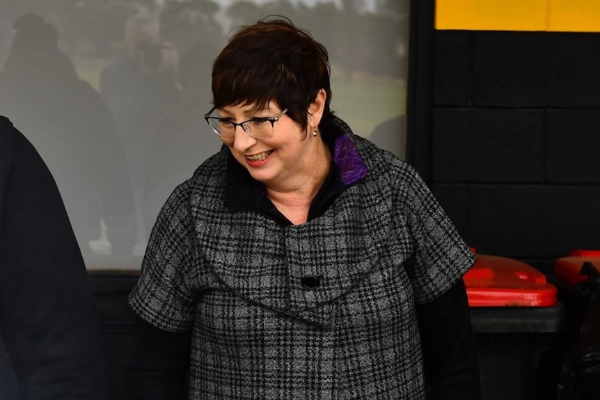 A woman in a winter coat and glasses.