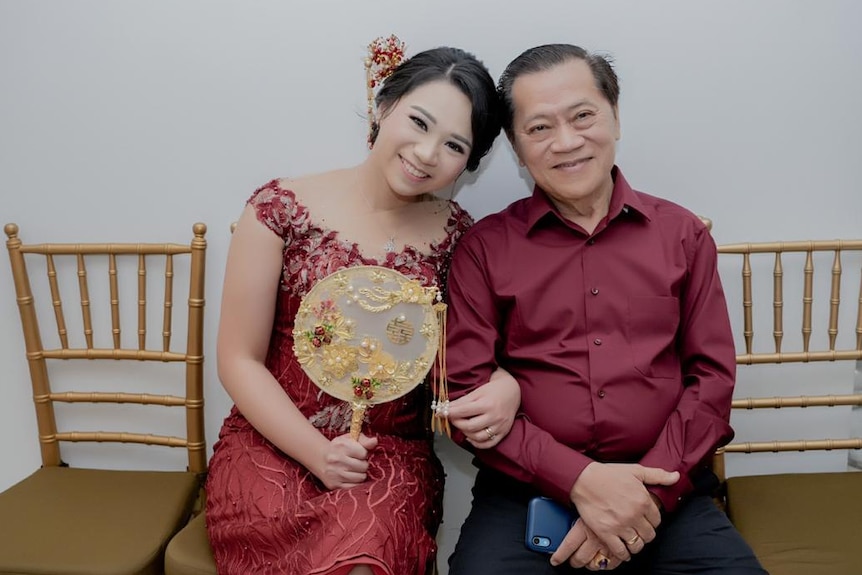 A woman and a man sitting together in chair and smiling to camera