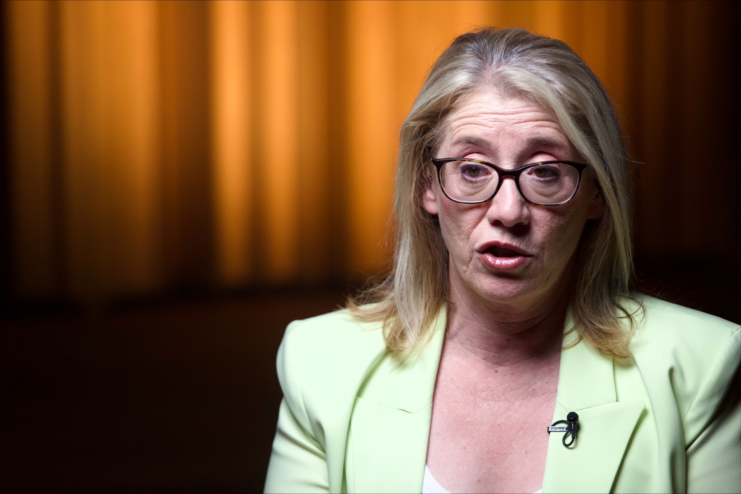 A close-up head and shoulders shot of WA Treasurer Rita Saffioti wearing a green jacket and white top during an interview.