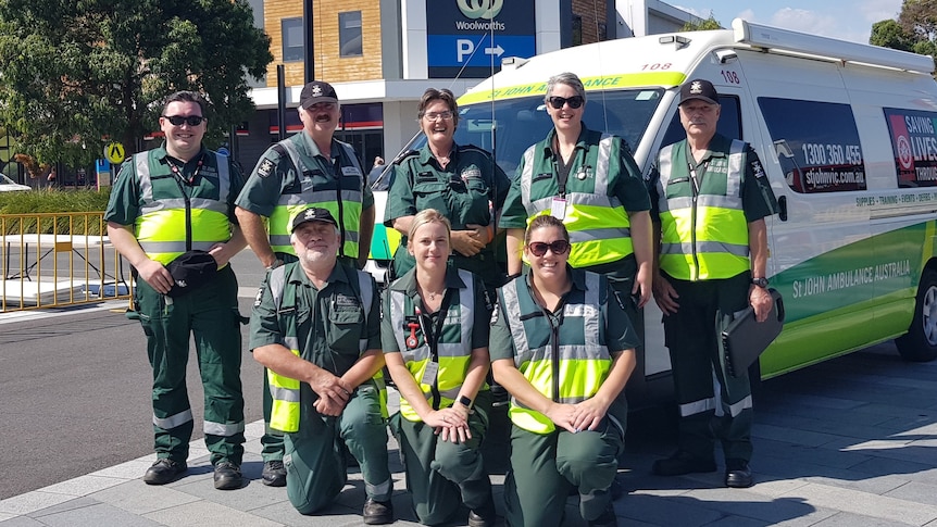 Eight people in St John uniforms standing in front of an ambulance in Wodonga