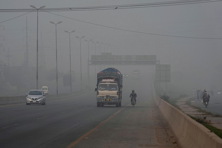 truck and cars on a highway with extremely low visibility surrounded by smog