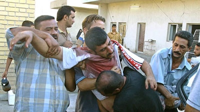 A wounded Iraqi man is taken to Al-Karama hospital following heavy clashes in the centre of the Iraqi capital Baghdad.