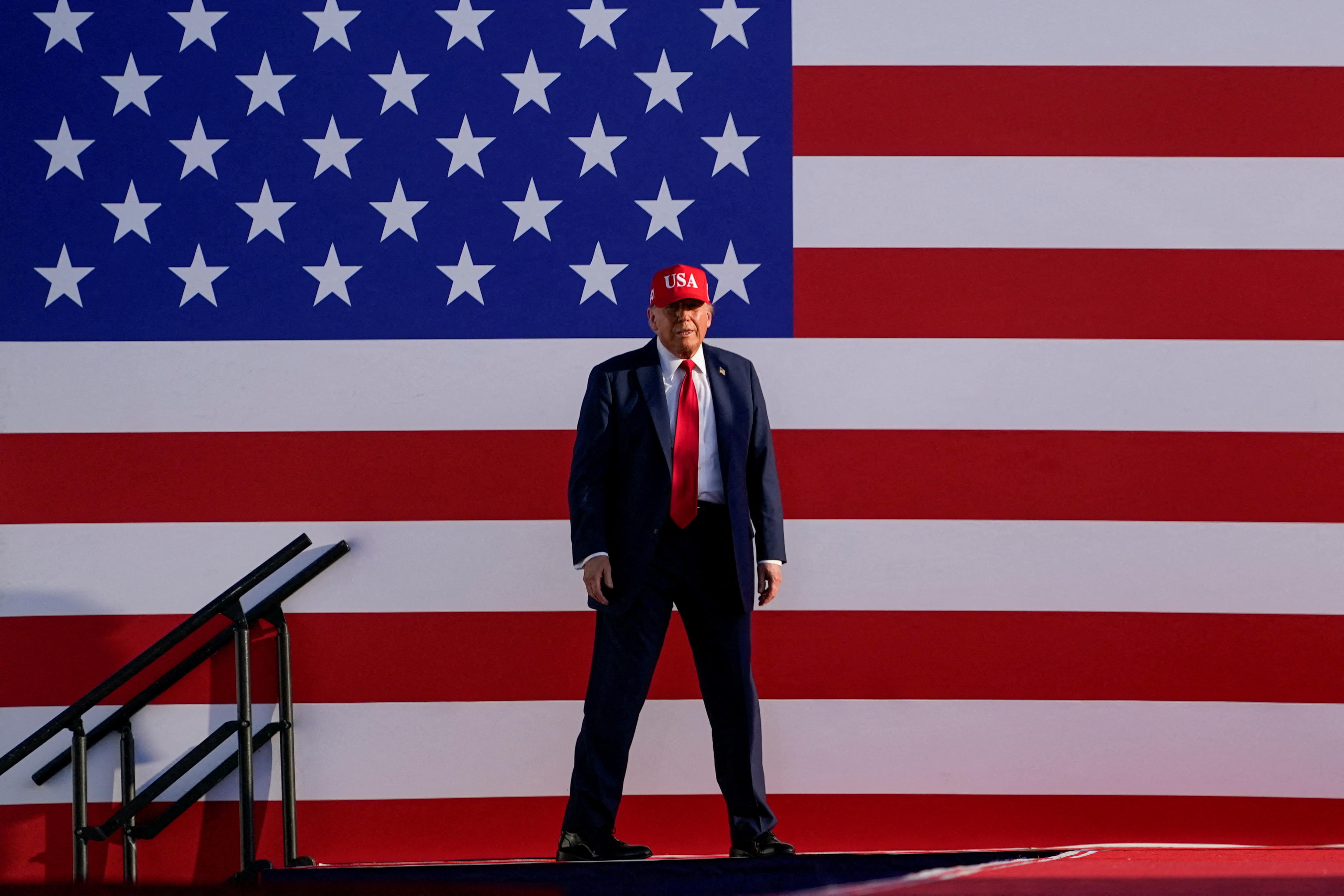 Trump on stage in front of a US flag