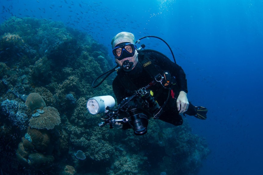 Man in diving gear underwater with underwater camera