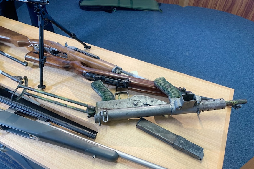 WWII 2 submachine gun sits among other firearms displayed on a table
