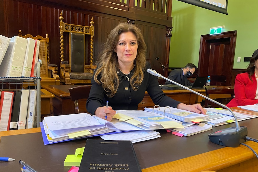 A woman sitting at a table inside a courtroom