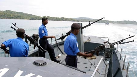 Sri Lankan Navy sailors man their guns as they patrol on a boat in Trincomalee.