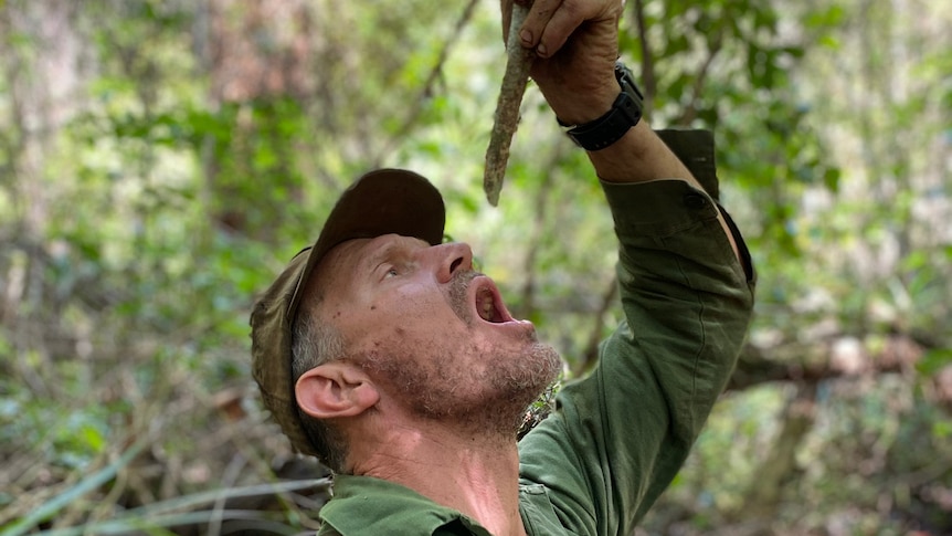 Gordon Dedman in the bush drinking from a native plant