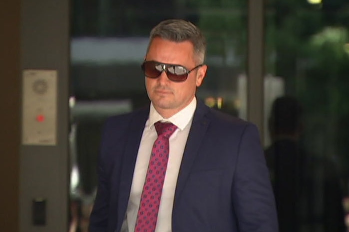 Senior Constable Murray Gentner, wearing sunglasses, leaves court.
