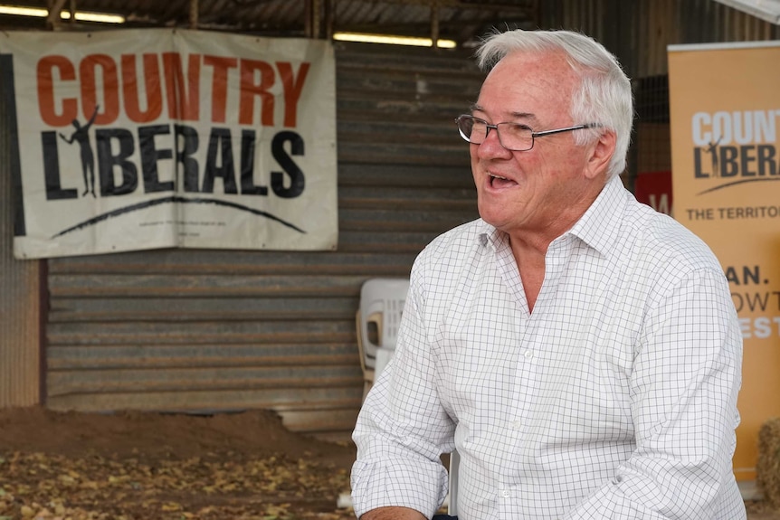 Gary Higgins, leader of the CLP opposition, in front of CLP posters at the Katherine Show.