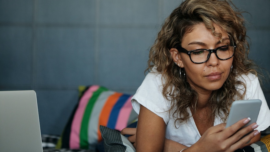 woman looks on phone