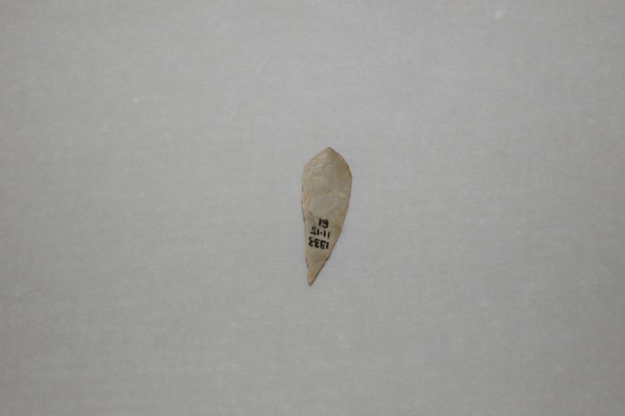 A small rock carved into a sharp triangular shape, labelled with a date and filing number.