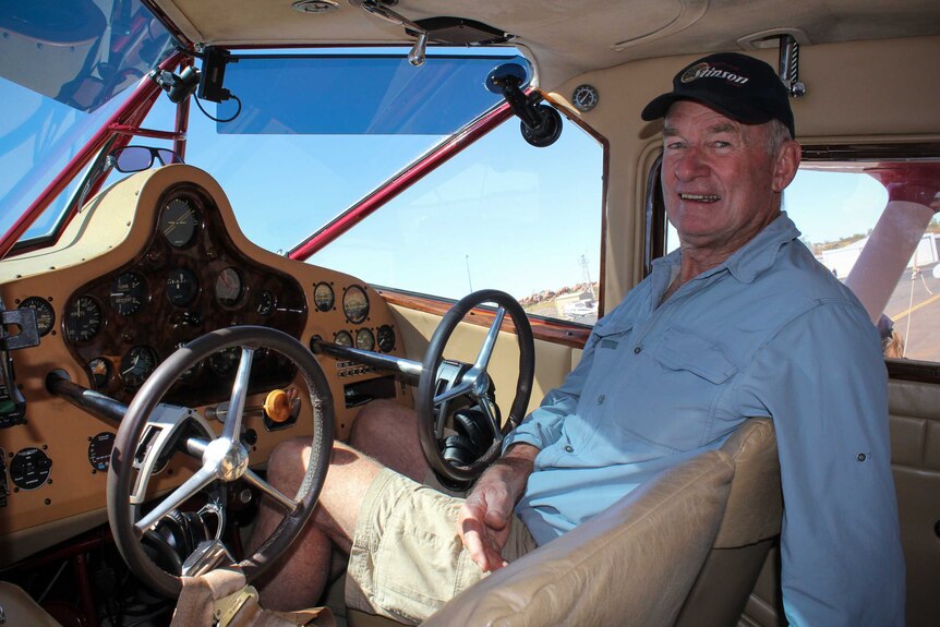 Kevin Bailey sitting in the pilot seat of his antique plane.