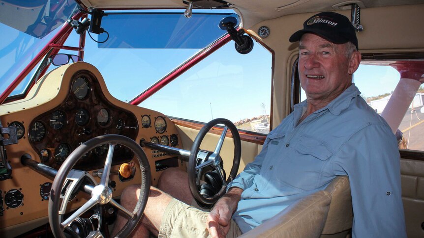 Kevin Bailey sitting in the pilot seat of his antique plane.