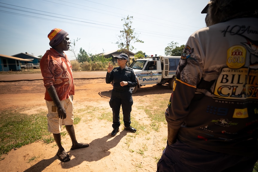 Senior Sergeant Erica Gibson talking to two people on a street in Wadeye.