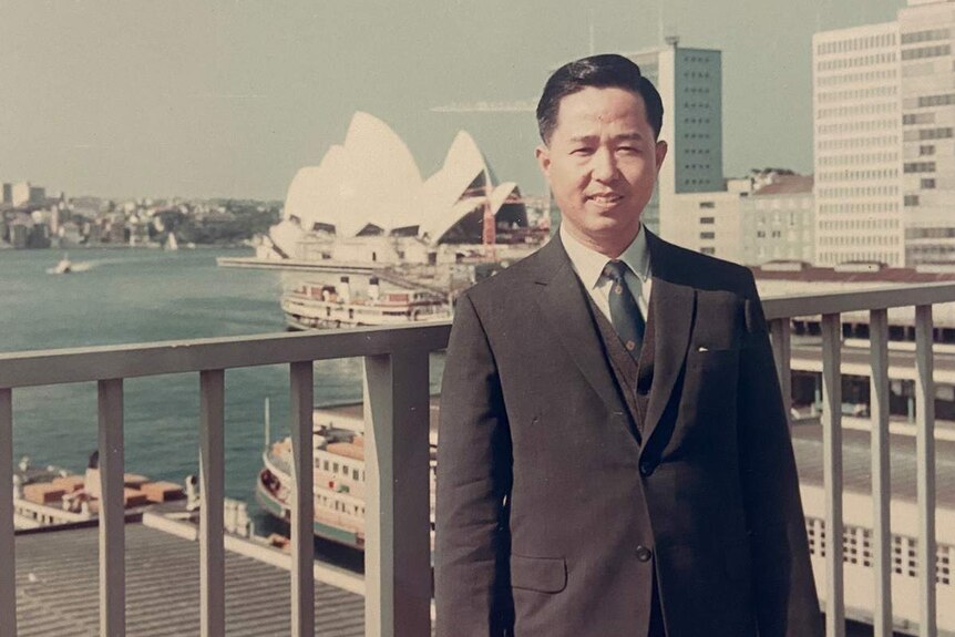 A young Chinese man outside the Sydney Opera House.