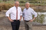 Scott Morrison and Michael McCormack stand on the dried out part of a receding dam