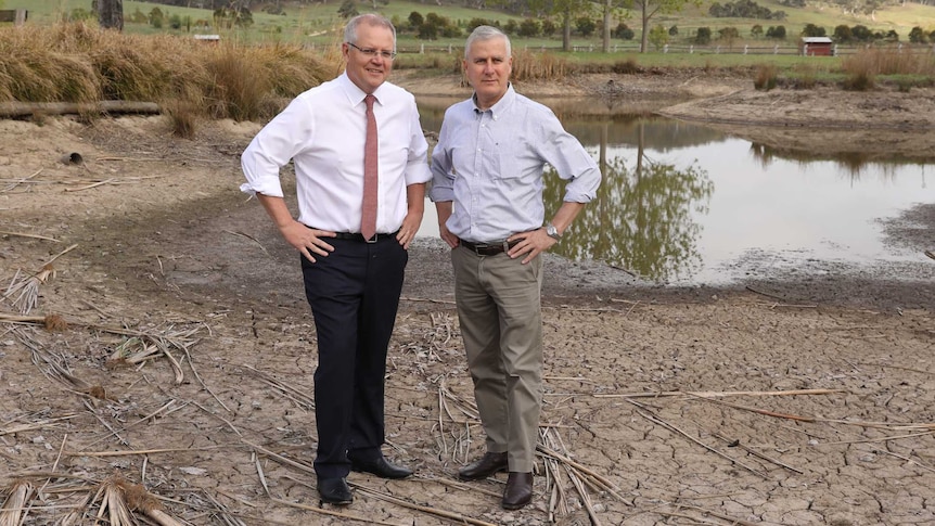 Scott Morrison and Michael McCormack stand on the dried out part of a receding dam