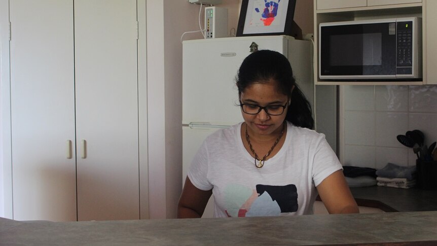 A woman stands in the kitchen