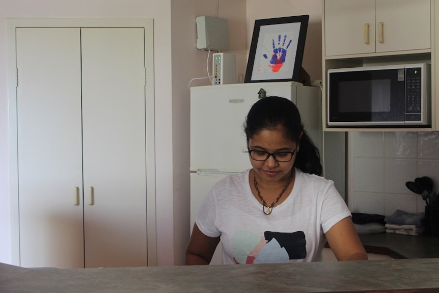 A woman stands in the kitchen