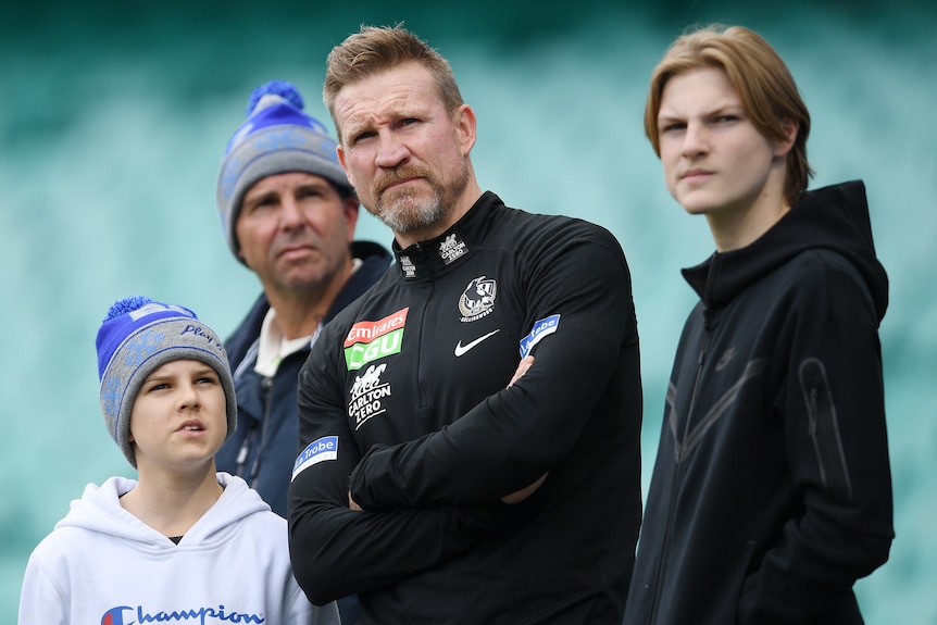 L'entraîneur de l'AFL de Collingwood photographié debout avec ses deux fils au SCG.