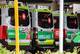 The back of three ambulances, and the bonnet of a fourth, parked outside a hospital.