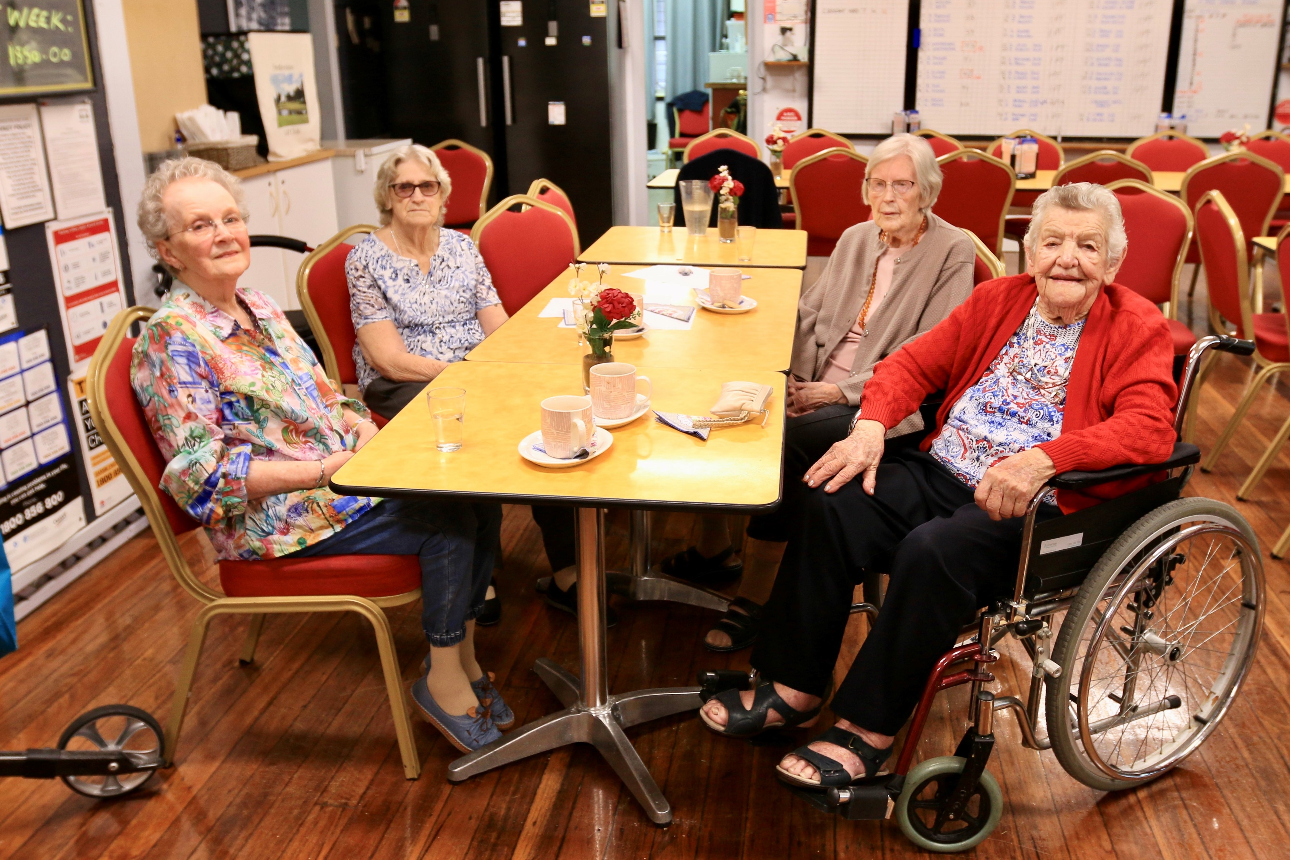 A group of four elderly women sitting around a table in a bistro