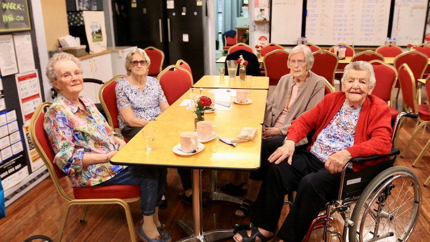 A group of four elderly women sitting around a table in a bistro