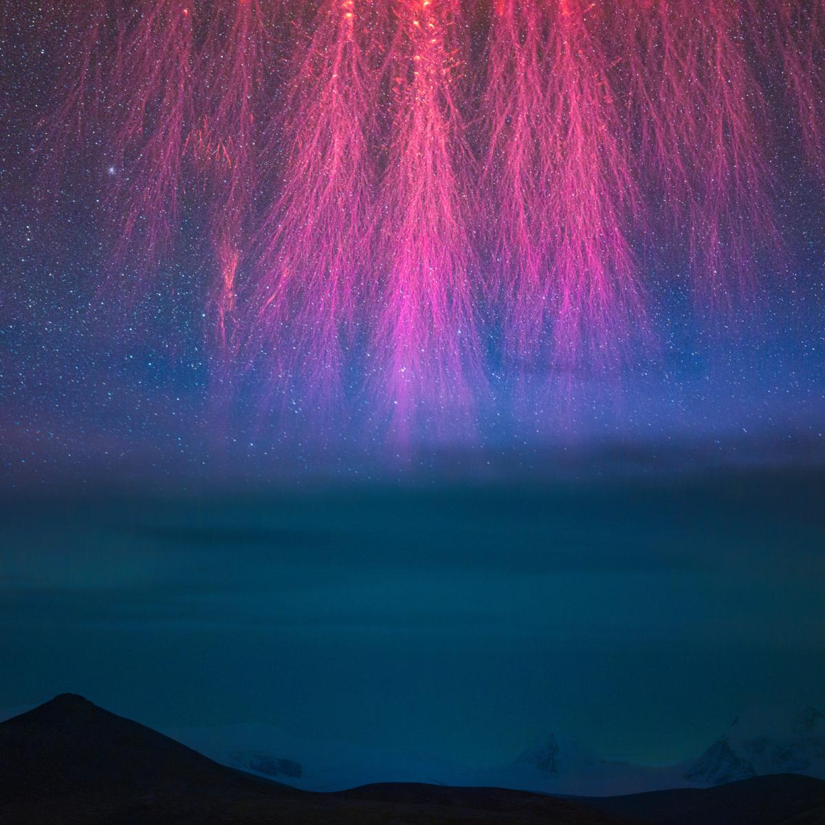 Imagen espacial con fuegos artificiales de color rosa sobre un fondo azul con estrellas