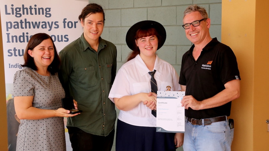 An Indigenous student is presented with a certificate for her work in science, technology, engineering and maths.