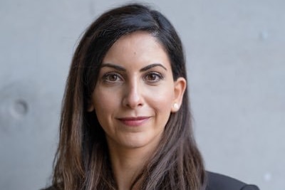 A headshot of a woman in a suit looking at the camera